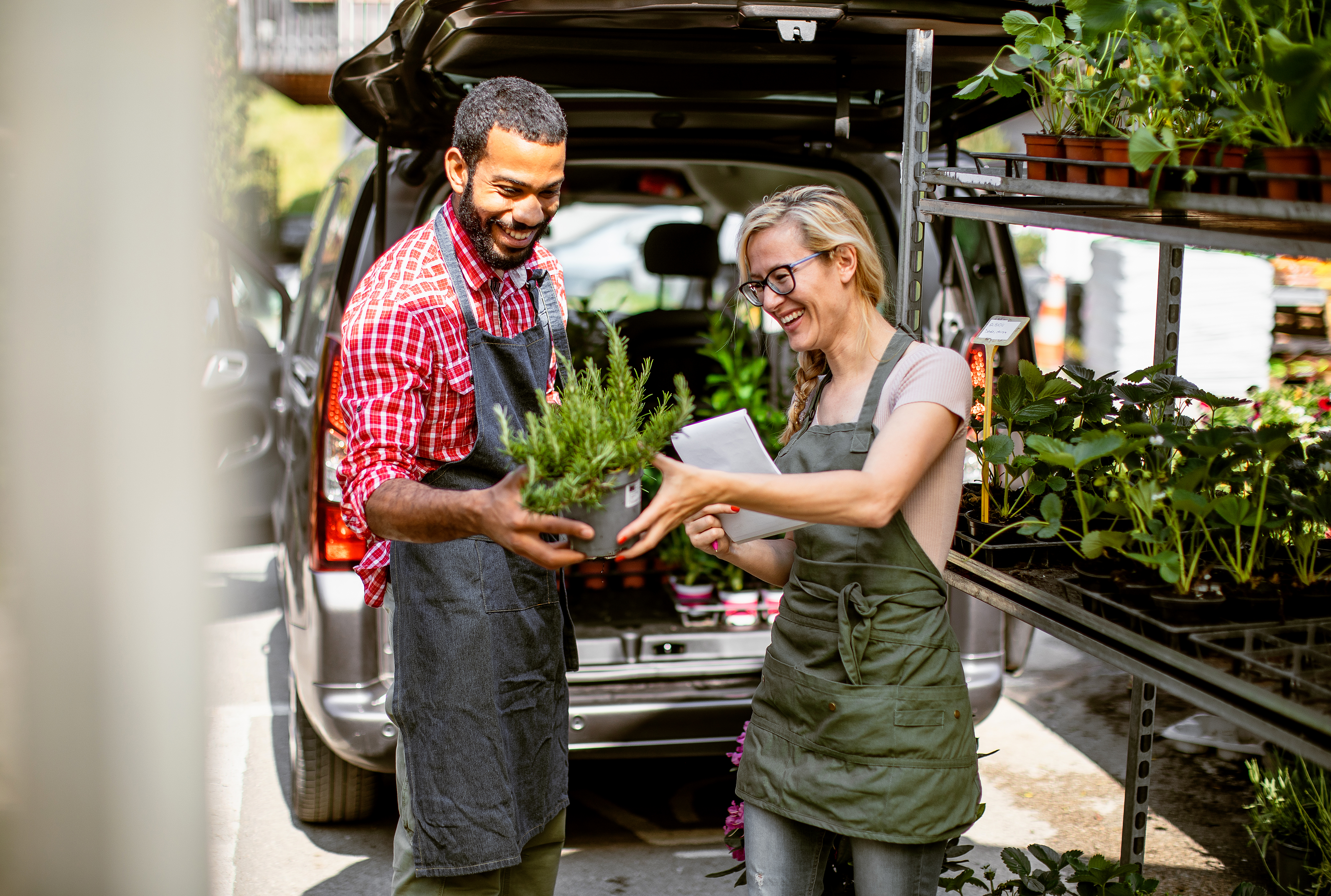 Image of two gardening workers loading plants into a van to symbolize how Cox 2M  IoT technology can elevate the customer experience. 