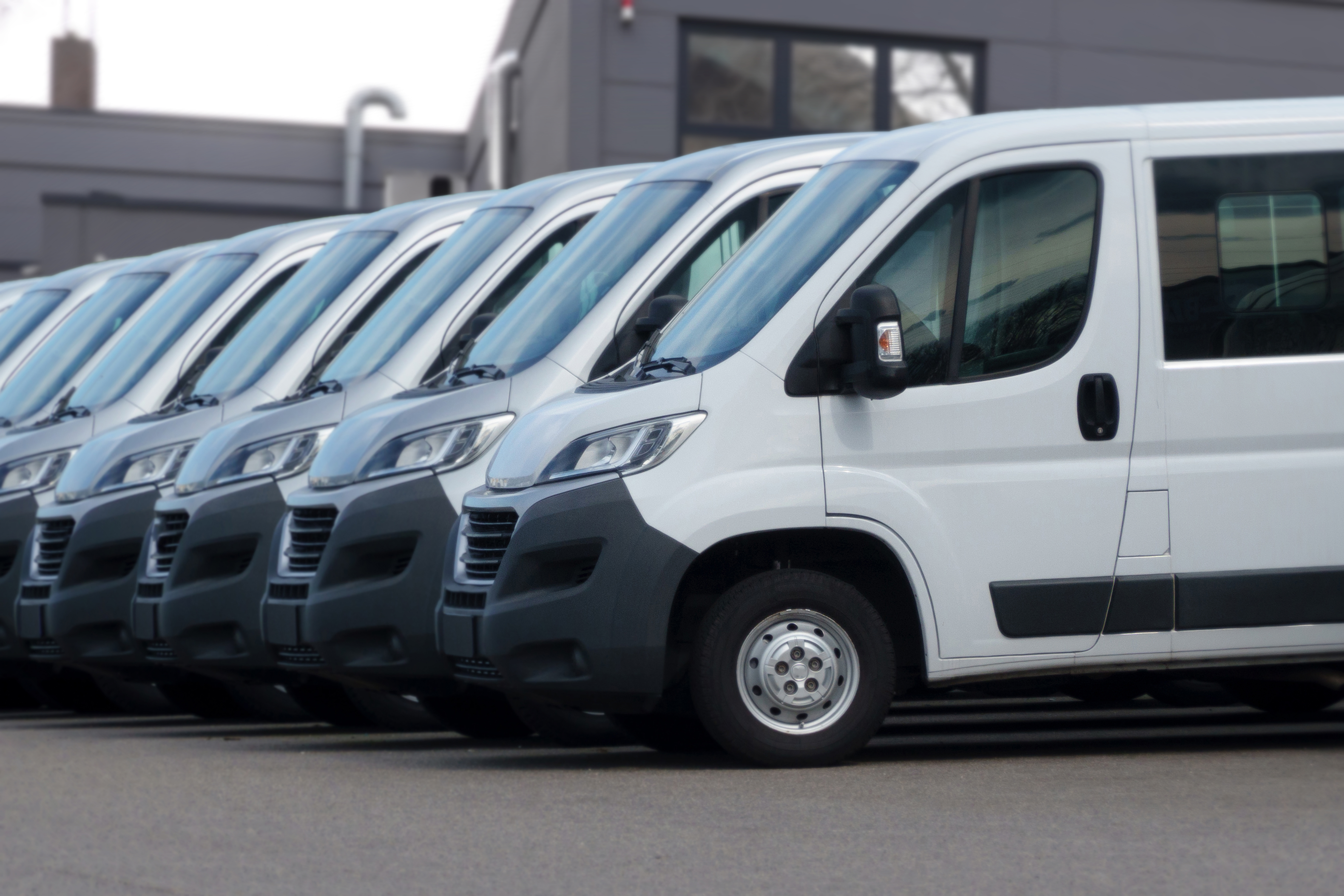 Image of a row of white vans to symbolize Kayo small business fleet management offering.